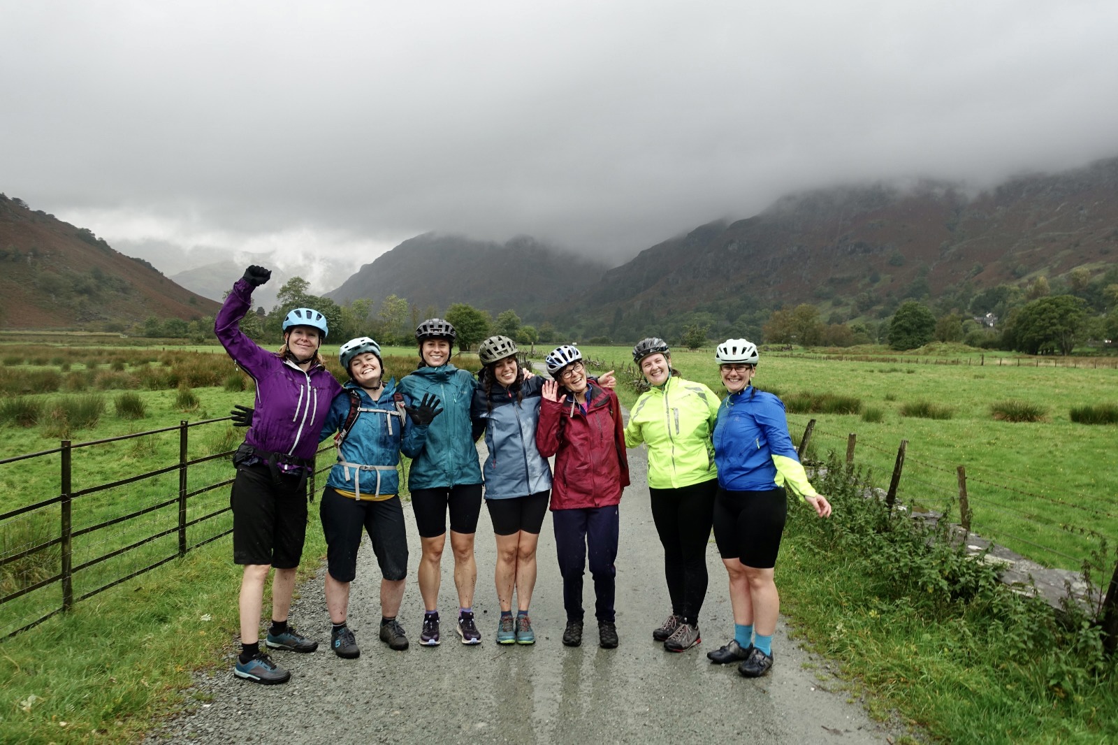 A group of women in colourful jackets smiling and cheering for a group photo