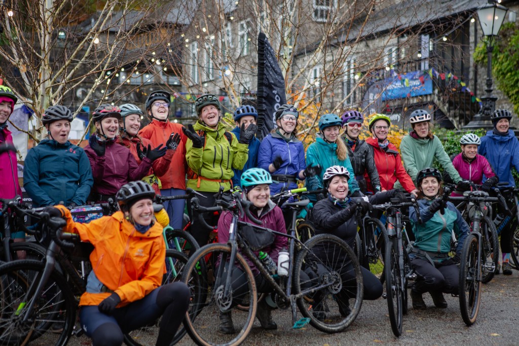 A group of women in colourful jackets smiling for a group photo