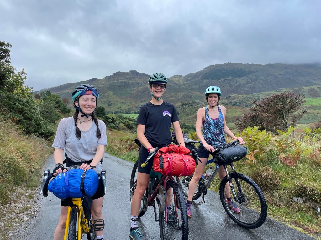 three women smiling at the top of a hill