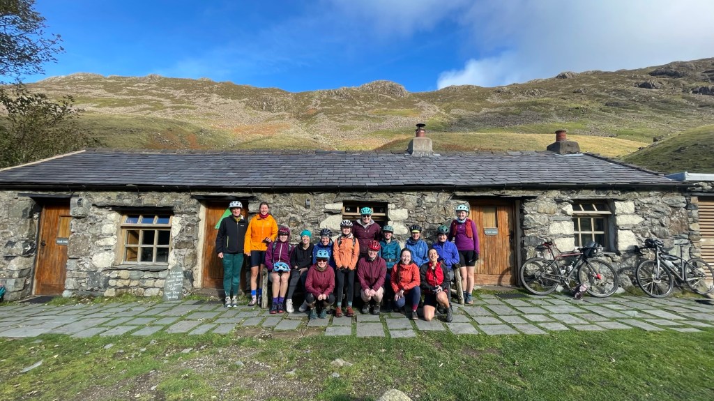 large group of women posing for a group photo infront of a building